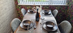 A dining table set with plates, bowls, wine glasses, and cutlery. - The Hideaway ll /enclosed Garden/quiet/central (Southport)