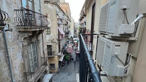 Una calle estrecha flanqueada por edificios, con balcones y unidades de aire acondicionado.