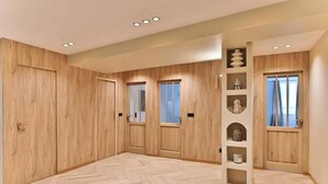 Ein geräumiges Zimmer mit Holzvertäfelung, Einbauschränken und einer zentralen Regaleinrichtung.