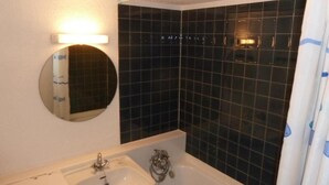 A bathroom with a sink, mirror, and black tiled walls. - 300m from ski slopes, 2nd floor, balcony, parking, tv, ski locker, 22m², Valloire (Valloire)
