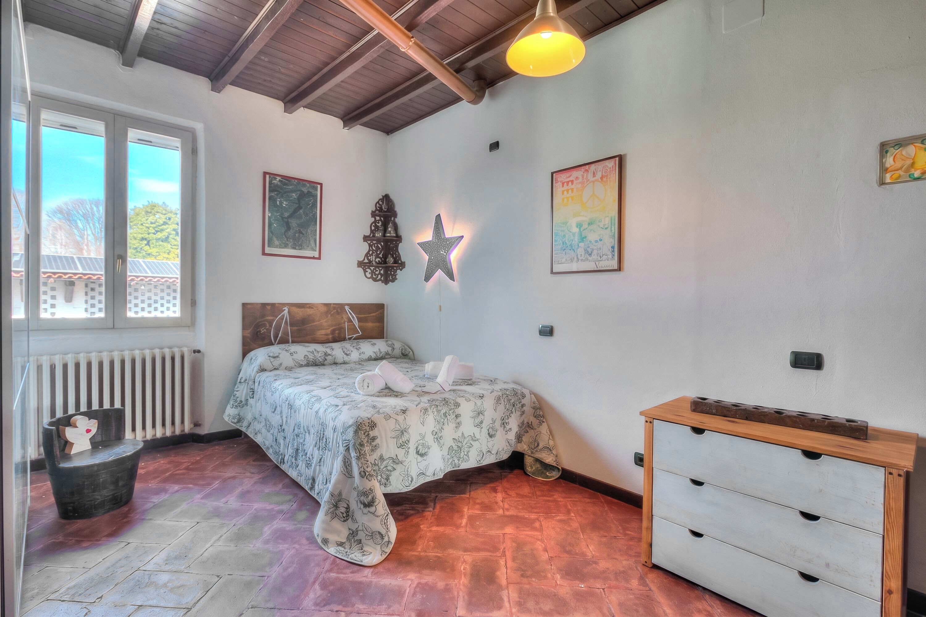 A bedroom with a bed, a dresser, a star decoration, and a radiator.
