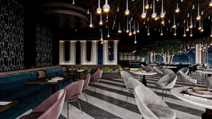 A modern restaurant interior with striped flooring, round tables, and plush chairs. - Renex Hotels (Antalya)