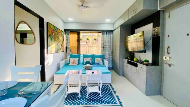 A compact living space with a bed, a dining area, a TV, and a kitchenette. - Charming 3 Bed 2 Bath in Bandra West with Balcony
 (Mumbai)