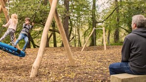Un parque con un columpio y una banca.