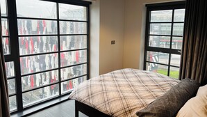 Una camera da letto con un letto, ampie finestre e una lampada a sospensione.
