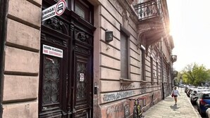 A building with a dark wooden door and a sign that reads "Brama Wjazdowa Nie Zastawiaca!" - SquadGoals House by Fragola Apartments (Kraków)