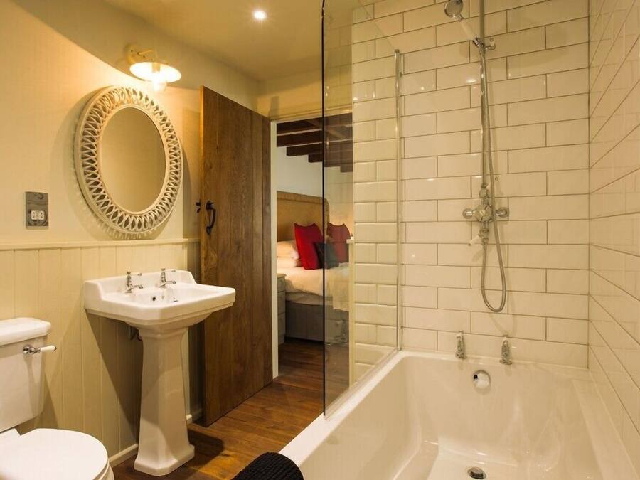 Une salle de bain avec un lavabo, des toilettes et une baignoire, le tout de couleur blanche.