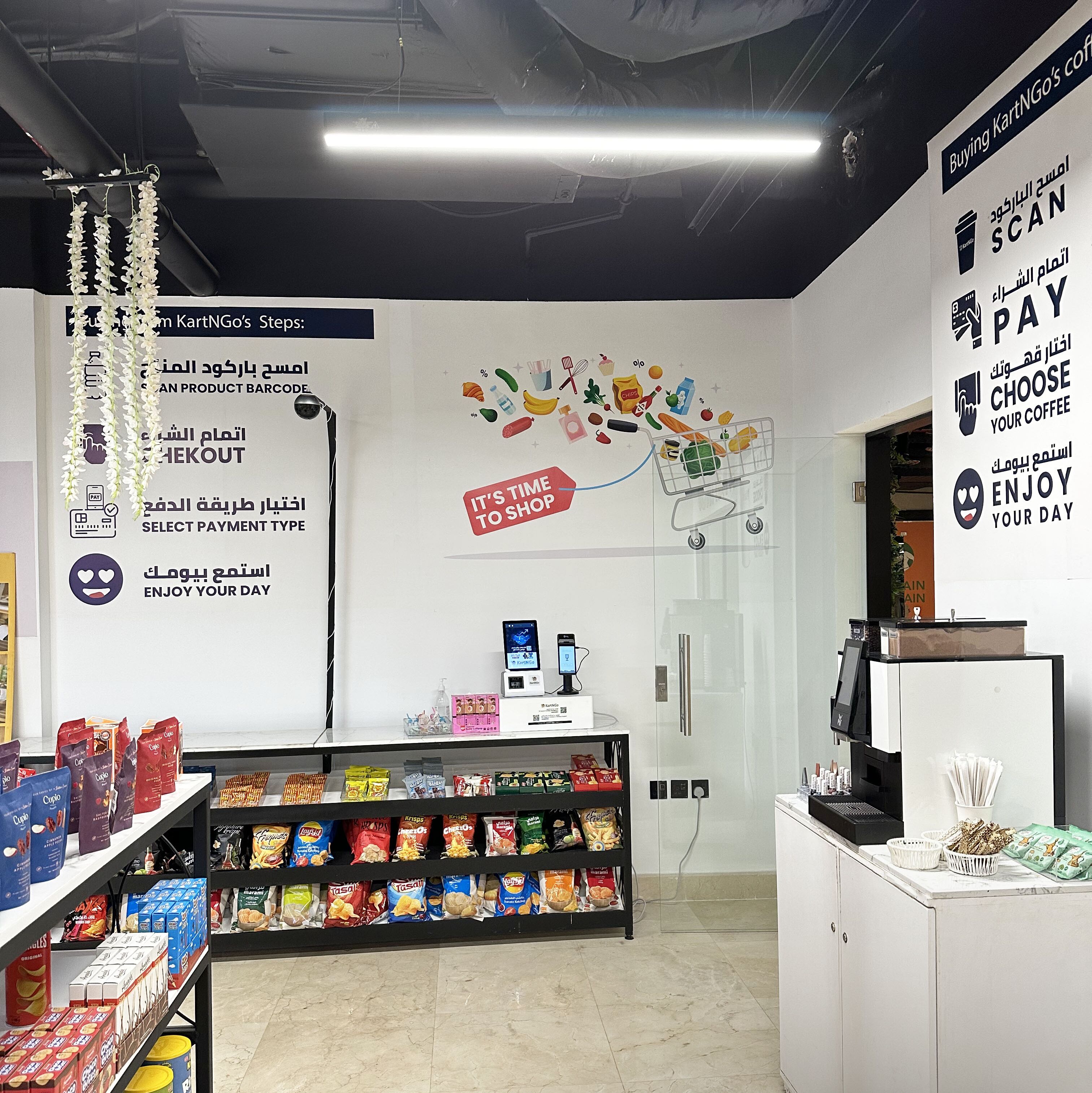 Ein Supermarktinneres mit Regalen voller Snacks, einer Kasse und einer Wand mit Werbegrafiken.