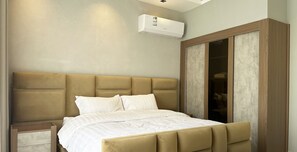 Ein Schlafzimmer mit einem großen Bett, einem Holzschrank und einer Klimaanlage an der Wand.