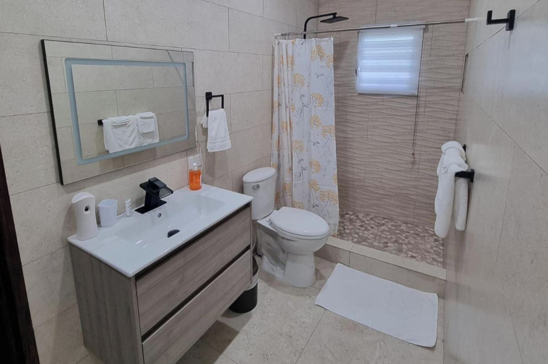 A bathroom with a sink, toilet, and shower.
