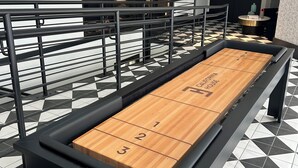 A shuffleboard table in a hotel lobby with a checkered floor pattern and a modern interior design. - Cozy 2BR Apt in Arlington, VA. Minutes from  Washington D.C. (Arlington)