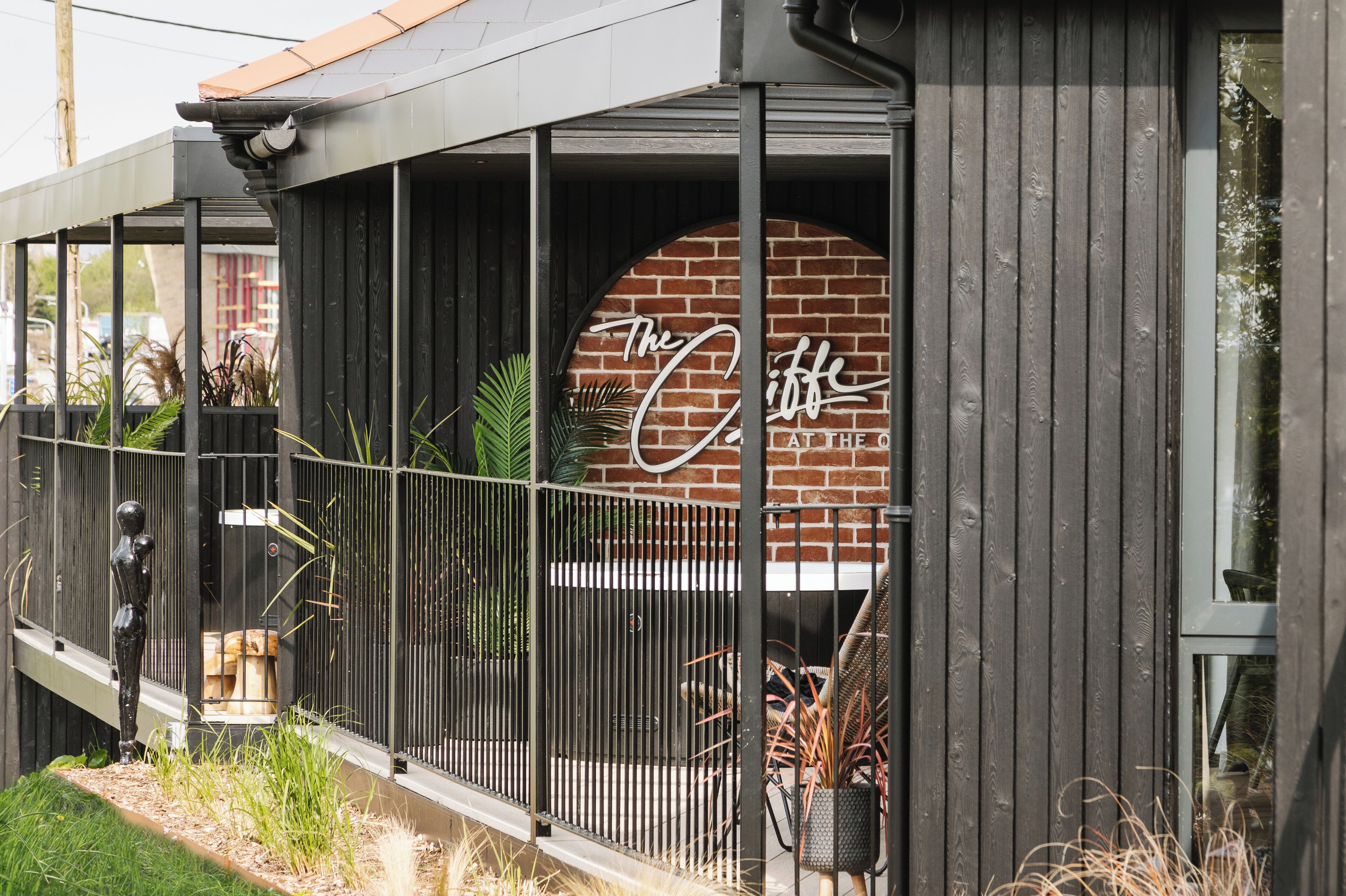 A building with a brick facade and a sign that reads "The Cliche."