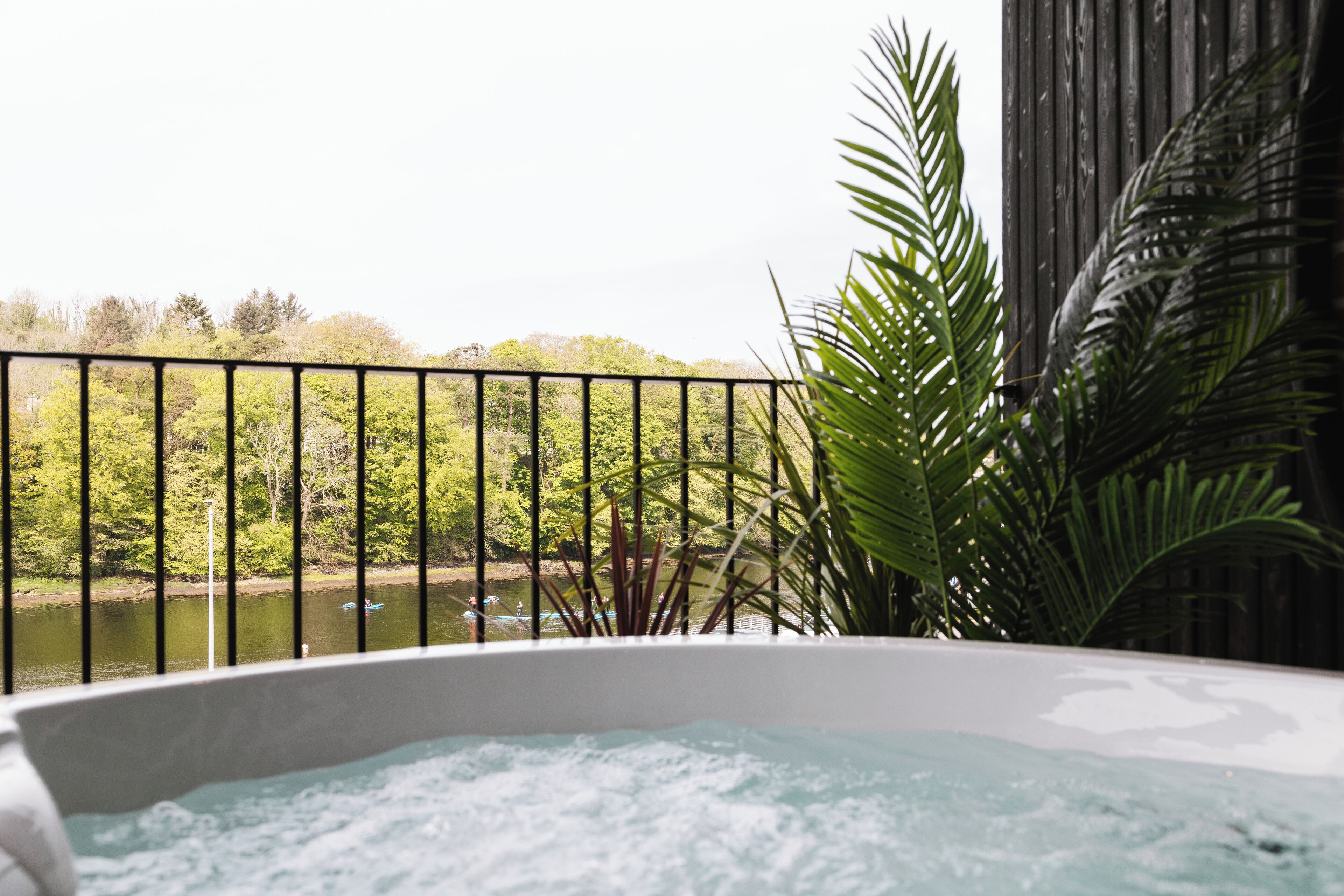 Un jacuzzi con vista a un lago y árboles.