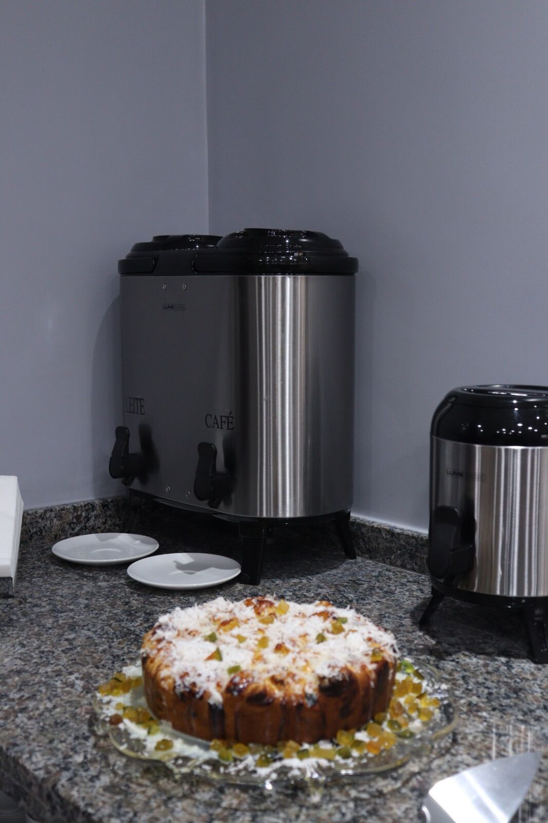 A kitchen with a stainless steel slow cooker, a toaster, and a plate with a baked dish.