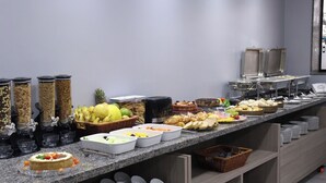 A buffet with various food items and containers. - Hotel Place Jardin (Garanhuns)