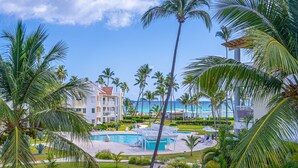 Ein Resort mit Poolanlage, Palmen und Meerblick.