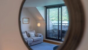 Habitació moderna amb un finestra gran, un sofà i una làmpada.