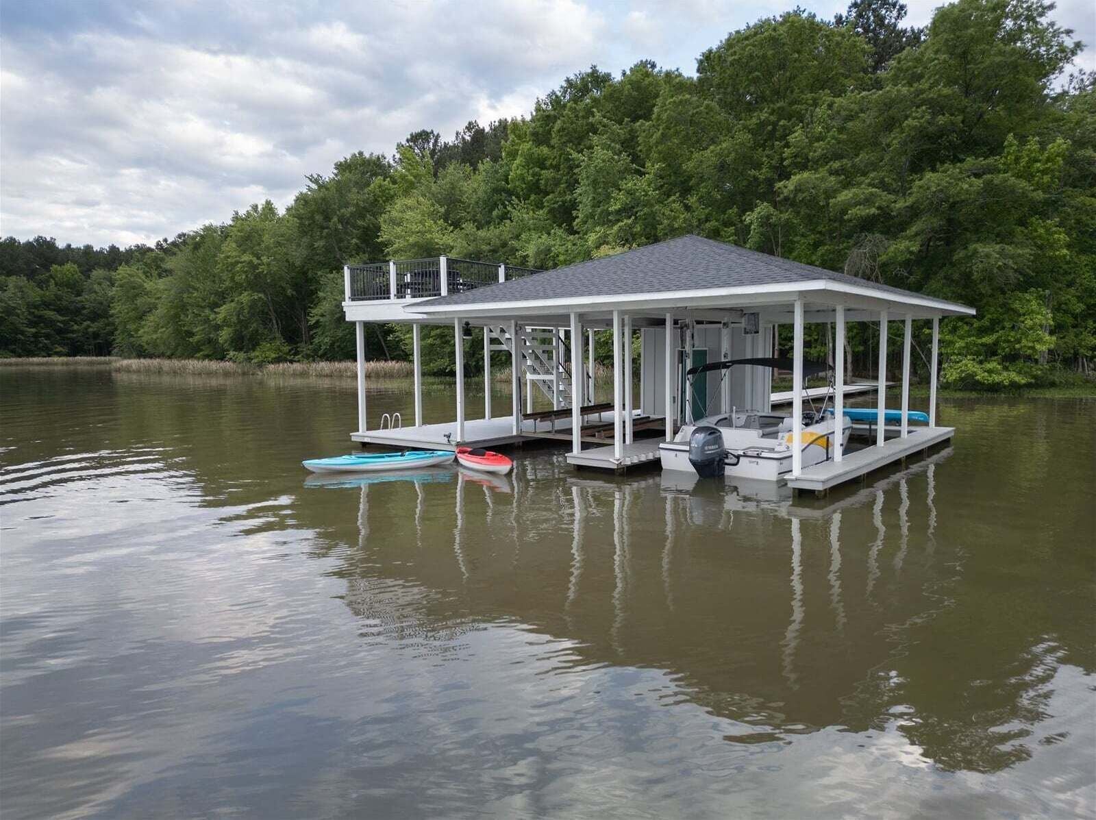 A dock with a covered structure, a small boat, and a motorboat.