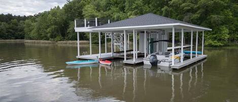 A dock with a covered structure, a small boat, and a motorboat.