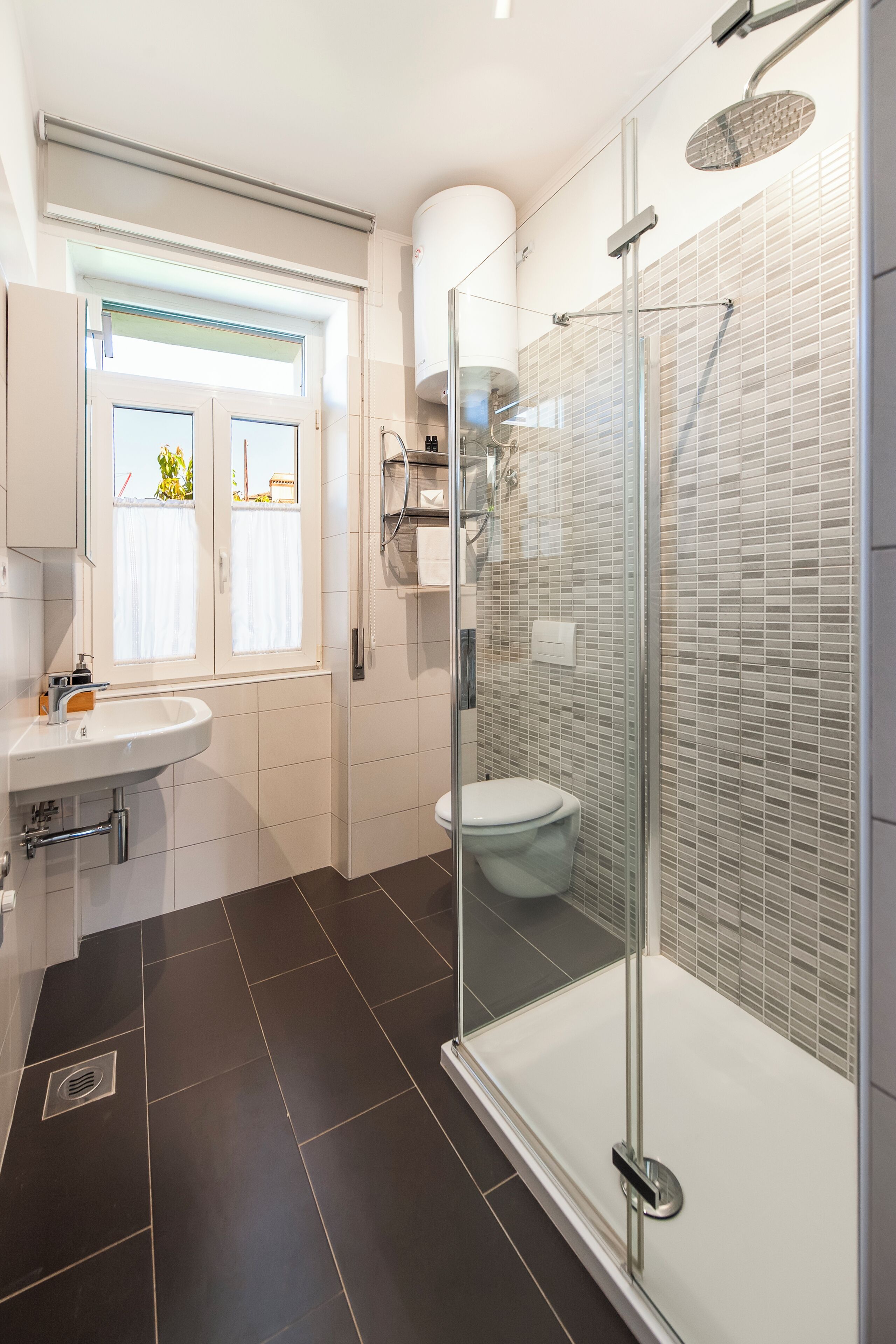 Une salle de bain moderne dotée d’une douche à parois de verre, de toilettes et d’un lavabo.