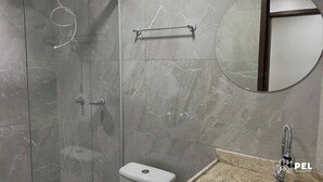 A modern bathroom with a glass shower enclosure, a toilet, and a sink with a mirror. - Pel Apart Hotel  (Pelotas)