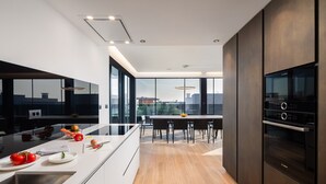 A modern kitchen with a central island, a dining area with a view, and a Bosch oven. - Luxury villa with swimming pool and sauna near Pula. (Vodnjan)