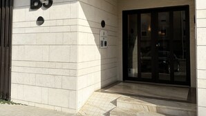 Ein Gebäudeeingang mit einem Schild 'B5' und einer Glastür.