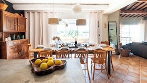 Enjoy meals in this cozy dining area with a wooden table, exposed beams, and a large window.