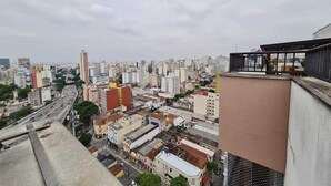 Un paysage urbain avec de hauts immeubles, une rue animée et un bâtiment moderne doté d’une façade en verre.