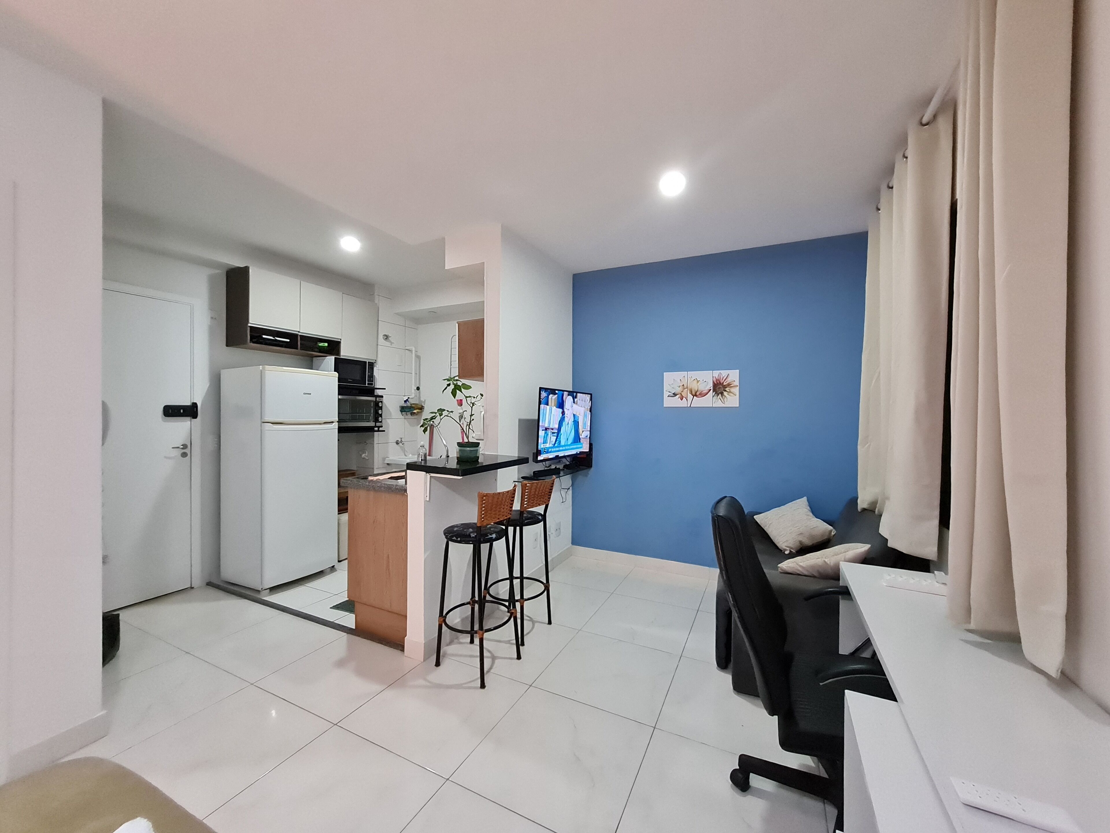 A compact living space with a kitchenette, a dining area with a table and chairs, and a seating area with a sofa.