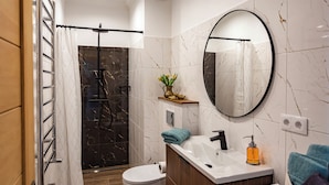 Un baño moderno con ducha, inodoro y lavamanos.