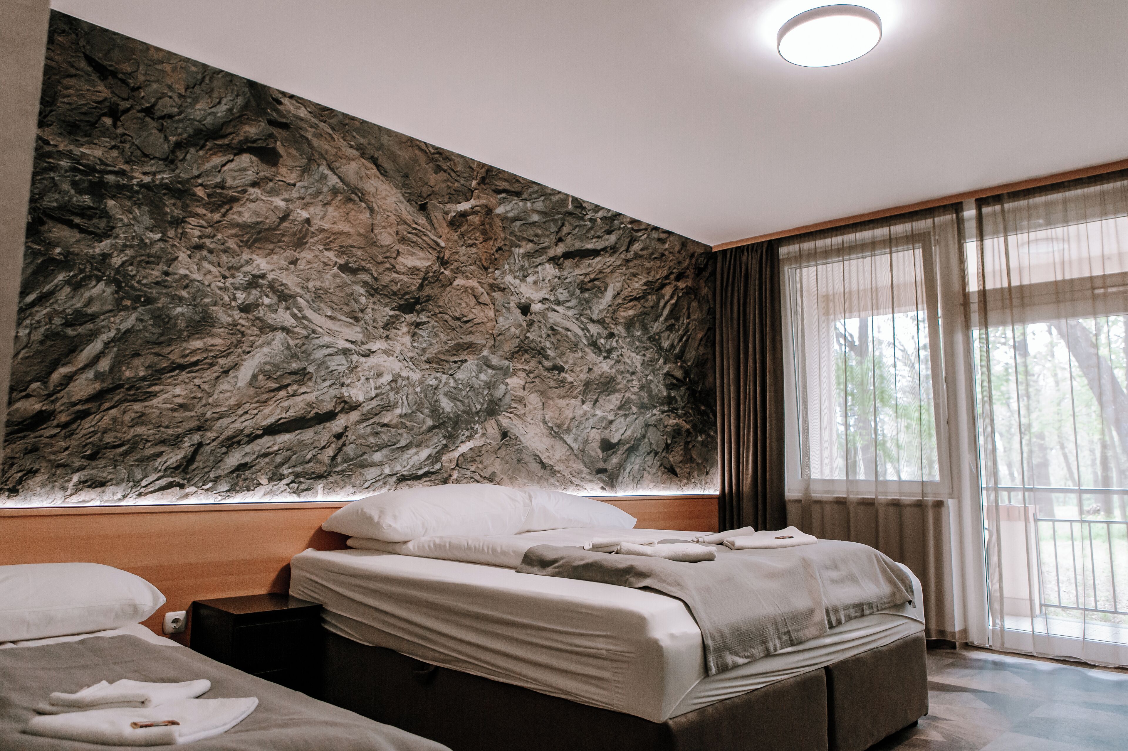 Un dormitorio con una cama grande, una mesita de noche y una pared con un diseño texturizado.