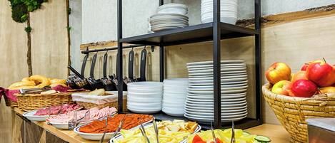 Una mesa de buffet con diversos alimentos y utensilios.