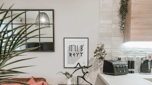 A modern kitchen with a white countertop, a toaster, and a hanging light fixture. - Stylish 1Bed Apartment in Sheffield CC (Sheffield)