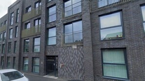 A multi-story building with a brick facade, large windows, and a gated entrance. - Stylish 1Bed Apartment in Sheffield CC (Sheffield)