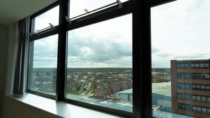 Una habitación con un ventanal grande con vistas a un paisaje urbano.