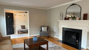 Un salon avec une cheminée, un canapé, une table basse et un fauteuil.