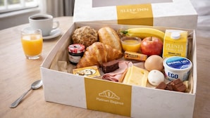 A breakfast box with a variety of food items including bread, eggs, cheese, and juice. - Kyoto Suites - Sleep inn Antwerp (Antwerp)
