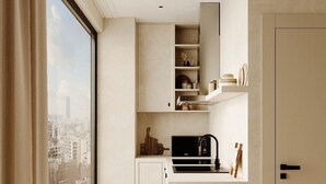 A modern kitchen with built-in cabinets, a black microwave, and a sink. - Kyoto Suites - Sleep inn Antwerp (Antwerp)
