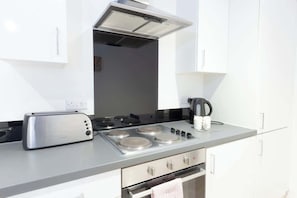 Una cocina moderna con estufa integrada, tostadora y hervidor.