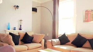 Una sala de estar con dos sofás, una mesa de centro y una lámpara.
