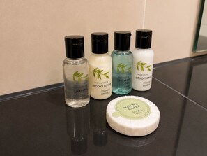Four bottles of body care products and a soap bar on a reflective surface. - Charming 2BR Flat in Sheffield City Centre (Sheffield)