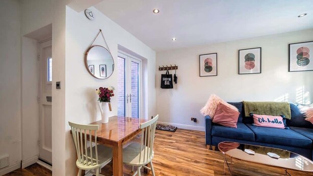 En moderne stue med spiseplads, en blå sofa og et sofabord.