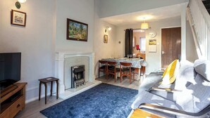A living room with a fireplace, a dining area, and a sofa. - Spacious House in Sheffield - Great Location! (Sheffield)