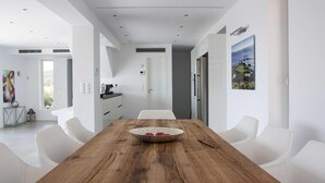 Ein moderner Essbereich mit Holztisch, weißen Stühlen und einer dekorativen Schüssel.