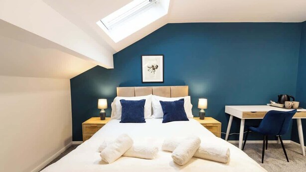 A bedroom with a bed, two bedside tables, a desk, and a chair. - Cosy Large Ensuite Room in the Heart of Oldham (Oldham)