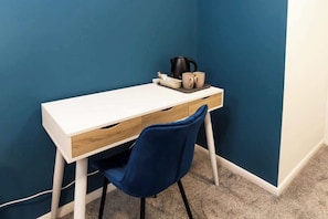 A small, modern room with a white desk, a blue chair, and a coffee maker on the desk. - Cosy Large Ensuite Room in the Heart of Oldham (Oldham)