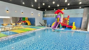 An indoor swimming pool with a checkered tile floor, surrounded by play structures and seating areas. - 3-bedroom Oasky Vung Tau with Partial Ocean View (Vung Tau)