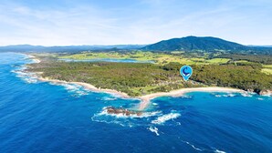 An aerial view of a coastal area with a beach, forested hills, and a mountain in the background. - 198 Mystery Bay Road, Mystery Bay (Mystery Bay)