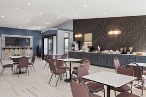 A modern hotel lobby with a bar area, seating arrangements, and a large wall-mounted TV. - Super 8 by Wyndham Fort Wayne (Fort Wayne)